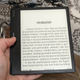 The Onyx Boox Leaf 2 held in one hand with an ebook displayed on screen.